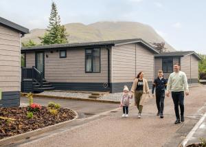 a family walking in front of a house at Ben Nevis Holiday Park in Banavie