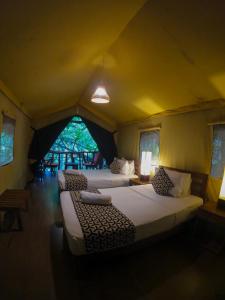 a bedroom with two beds in a tent at Athgira River Camping - Udawalawe in Udawalawe