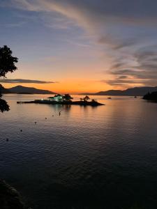eine Insel inmitten eines Sees bei Sonnenuntergang in der Unterkunft Apartamento Praia do Bonfim in Angra dos Reis
