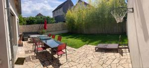 a patio with a table and chairs and a basketball hoop at Maison 20´de Paris et Disneyland in Noisy-le-Grand