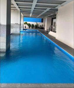 a large pool of blue water in a building at Cozy 54 sqm one bedroom unit with 400 mbps WI-FI and sunset skyline view in Manila