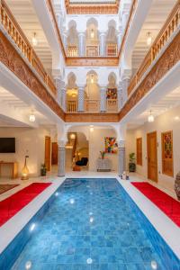 uma piscina interior num grande edifício com um grande tecto em Riad Atlas Palace Marrakech em Marraquexe