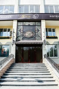 a hotel with stairs leading up to the front door at Vizit Hotel in Yekaterinburg