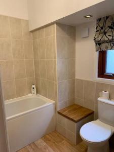 a bathroom with a toilet and a tub and a sink at Central 3 Bedroom Townhouse in Wick