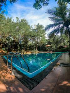 a swimming pool with a slide in a resort at Athgira River Camping - Udawalawe in Udawalawe