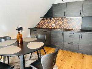a kitchen with two tables and chairs and a counter at FeWo 2 an der historischen Bahnlinie in Leutkirch im Allgäu