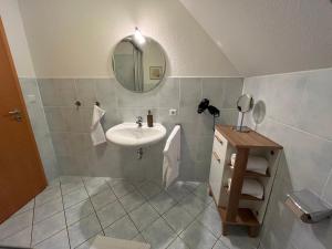 een badkamer met een wastafel en een spiegel bij FeWo 2 an der historischen Bahnlinie in Leutkirch im Allgäu