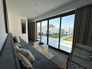 ein Wohnzimmer mit einem Sofa und einem großen Fenster in der Unterkunft container chalet in Buraida