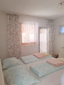 two twin beds in a room with a window at Lavanda in Vukovar