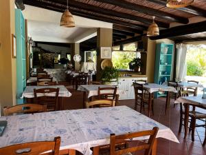 a restaurant with tables and chairs and a kitchen at Hotel Frassetto in Santa Teresa Gallura
