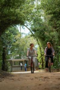 two people riding bikes down a dirt road at Athgira River Camping - Udawalawe in Udawalawe