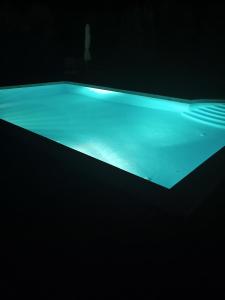 una piscina en una habitación oscura con iluminación azul en Relaxing rural retreat in mainland Greece, en Ermioni