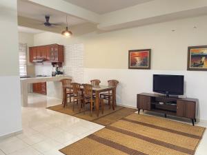 a kitchen and dining room with a table and a tv at Kuza Homes Batu Berendam in Melaka