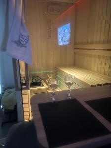 dois copos de vinho sentados numa mesa numa sauna em Lux studio sa saunom Ampelitsi em Ledine