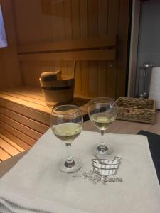 dois copos de vinho branco sentados numa toalha em Lux studio sa saunom Ampelitsi em Ledine
