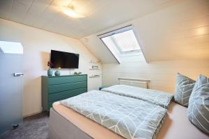 a bedroom with a bed and a flat screen tv at Fewo Seesternchen in Öhningen