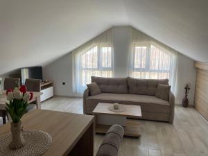 a living room with a couch and a table at Vuk apartment - Milmari Resort & Spa in Kopaonik
