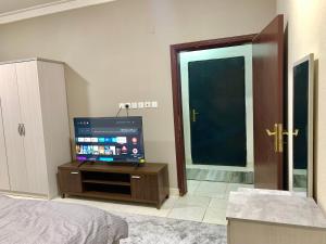 a bedroom with a flat screen tv and a bed at غرفة مزدوجة مدخل خاص دخـول ذاتي Private Room in Riyadh