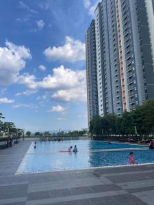 a swimming pool with people in it in front of a building at Santai at KotaWarisan KLIA Netflix in Sepang