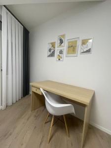 escritorio en una habitación con silla y cuadros en la pared en PristinaNEST, en Pristina