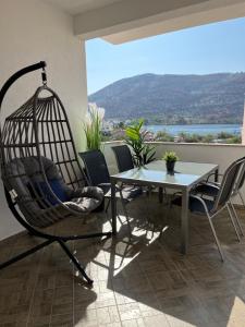 a swing chair and a table in a room at Sea View Apartments in Grebaštica