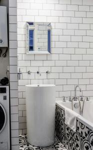 un bagno bianco con vasca e lavandino di Klimatyczne mieszkanie w centrum a Radom