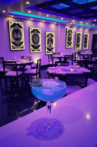 un restaurante con mesas, sillas y una copa de martini en XCELSIOR HOTEL & SPA, en Shillong