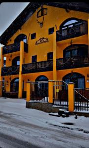 a yellow building with balconies on the side of it at Casa Lupascu in Vatra Dornei