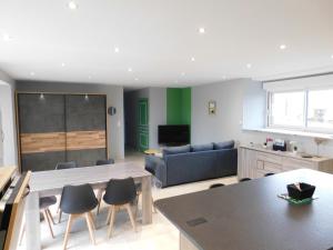 a living room with a couch and a table and chairs at gite de la laiserie in Mesnil-Clinchamps