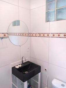 uma casa de banho com um lavatório preto e um WC. em Pousada Sol de Primavera em Arujá