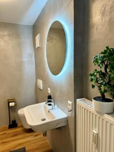 a bathroom with a sink and a mirror at Traumhafte Wohnung am Stadtbrunnen der Altstadt in Pfullendorf