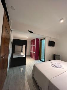 um quarto com uma cama branca e um espelho em Enseada Beach Hotel no Guarujá