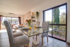 een eetkamer met een glazen tafel en stoelen bij Renovated Oasis 500m Beach AC Wi-Fi Pool Balcony in Albufeira