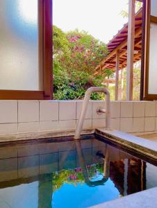 uma piscina com uma mangueira na água em 温泉付きの一軒家を借りよう em Beppu