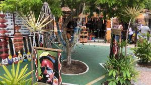 un parco con un parco giochi con un albero al suo interno di Ytamãní l apartamentos a Santa Cruz Cabrália Altre 5 foto