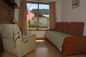 1 dormitorio con cama y ventana en Cabañas El Puesto Sur en El Chaltén