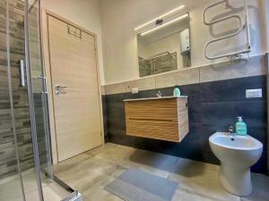 ein Bad mit einem WC, einem Waschbecken und einer Dusche in der Unterkunft Moderno Appartamento - Anzio in Anzio