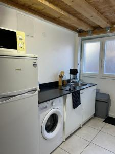 cocina con lavadora y fregadero en Studio cosy avec mezzanine, en La Verrière