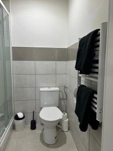 a bathroom with a white toilet and black towels at Studio cosy avec mezzanine in La Verrière