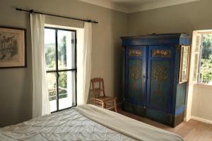 a bedroom with a blue cabinet and a window at Spiti Espede in Ágios Márkos