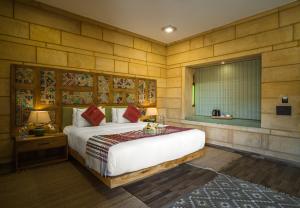 ein Schlafzimmer mit einem großen Bett und einem Fenster in der Unterkunft Hotel Grand Khalifa in Jaisalmer