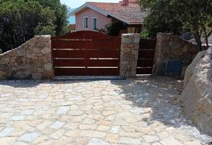 einen Zaun vor einem Haus mit einer steinernen Einfahrt in der Unterkunft Valle dell'Erica in Valle Dell’Erica