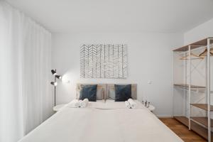 a bedroom with a large white bed with blue pillows at Sali Homes/ R1 Gemütliches Apartment am Fluss in Bayreuth