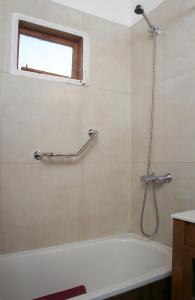 a bathroom with a bath tub and a window at Cabañas El Puesto Sur in El Chalten