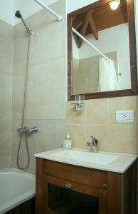 a bathroom with a sink and a mirror and a tub at Cabañas El Puesto Sur in El Chalten