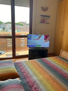 Schlafzimmer mit einem Flachbild-TV und einem Bett in der Unterkunft Residenza Versilia in Viareggio