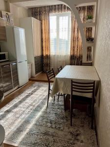 a kitchen with a table and chairs in a room at PROMENADE BISHKEK in Bishkek