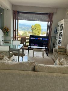 ein Wohnzimmer mit einem Sofa, einem Tisch und einem TV in der Unterkunft Residenza Versilia in Viareggio
