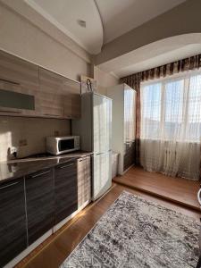 a kitchen with stainless steel appliances and a large window at PROMENADE BISHKEK in Bishkek