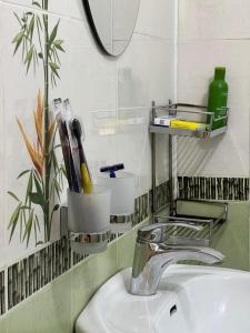 um lavatório de casa de banho com uma torneira e um espelho em PROMENADE BISHKEK em Bishkek